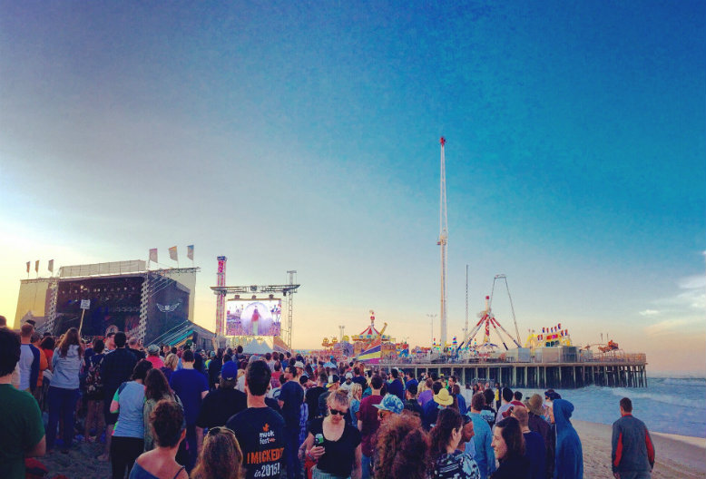 The sun sets on the beach as the pier lights come into view just before the Mumford & Sons take the stage. Photo by Lauren Bowers