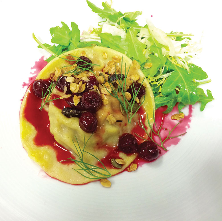 Duck and foie gras raviolo with cherry sauce.