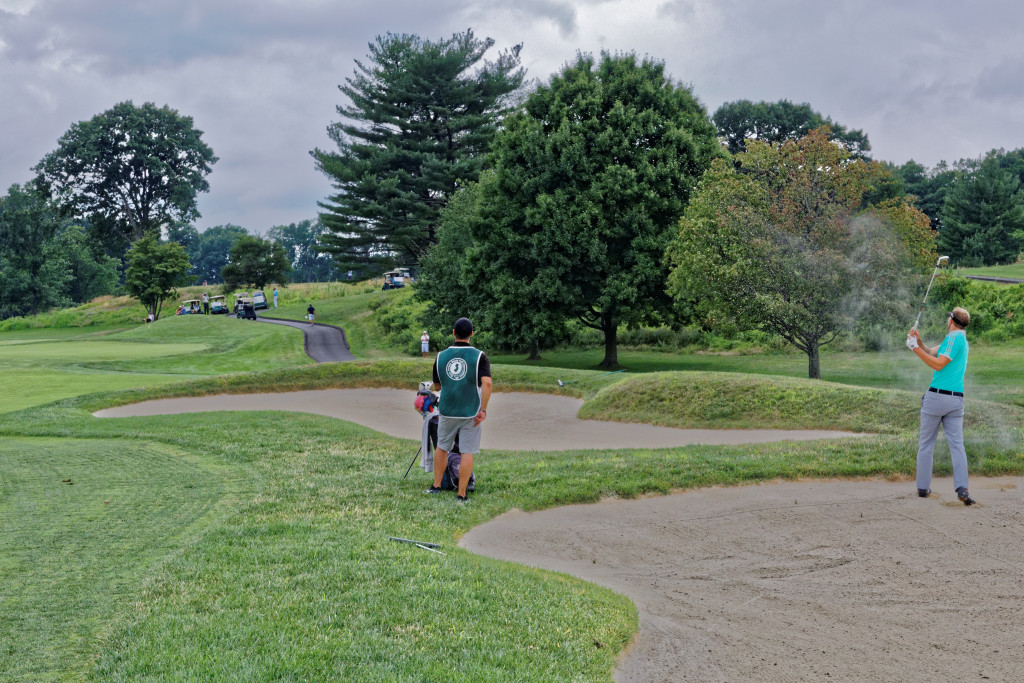 Hall executes an extremely difficult escape from the front edge of a fairway bunker on the 12th hole. His ball wound up at the throat of the green. He chipped close to the hole and had an easy putt for par. Photo: Eric Levin