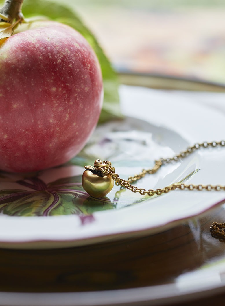 A gold apple necklace by Janet Mavec 