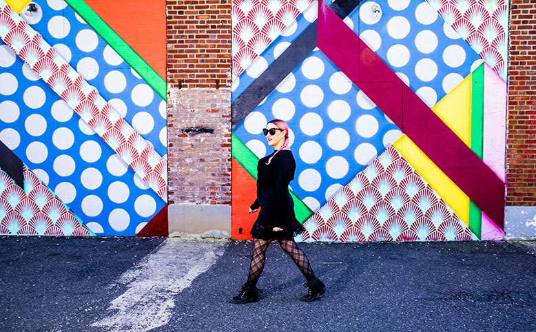 Jenn Hampton strolls in front of a colorful mural in Asbury Park