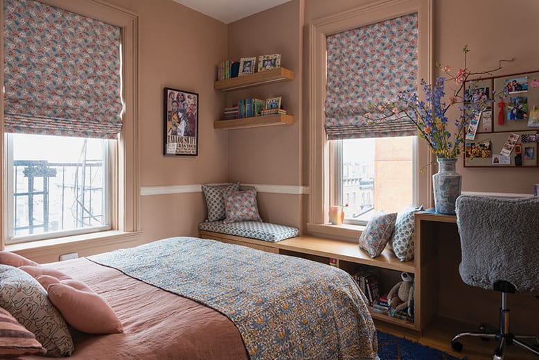 A tween daughter's bedroom with cotton bedding, patterned pillows and fabric shades in a Hoboken brownstone