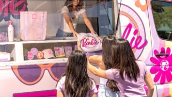 Young girls purchasing Barbie-themed merchandise from the Barbie Truck Tour