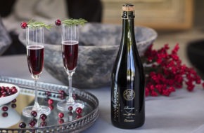 Two glasses of sparkling red wine on a table decorated for the holidays