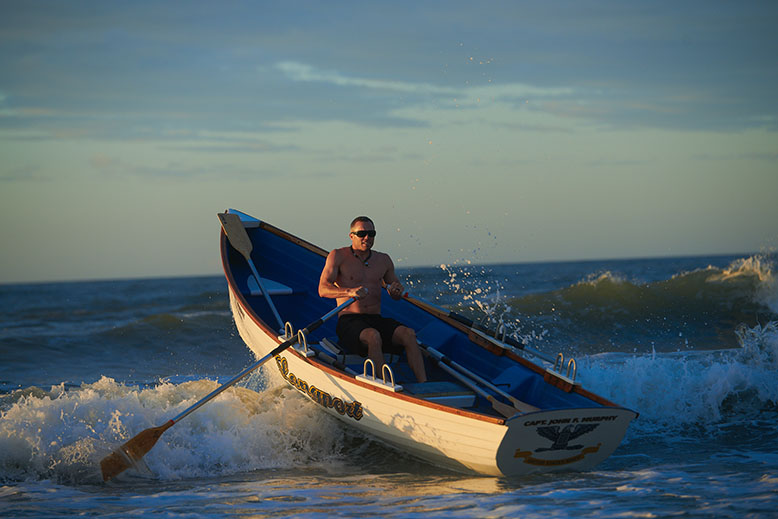 Tim Schwegman paddles a boat in the ocean at
