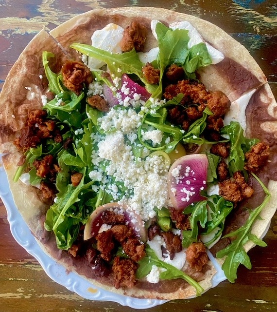 The open-face tlayuda, a house-made tortilla heaped with chorizo, at Uno Más in Allendale.