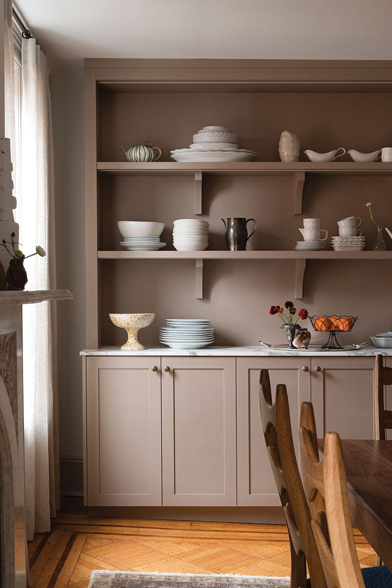 A dining room in a Hoboken brownstone displays heirloom serveware on open shelving