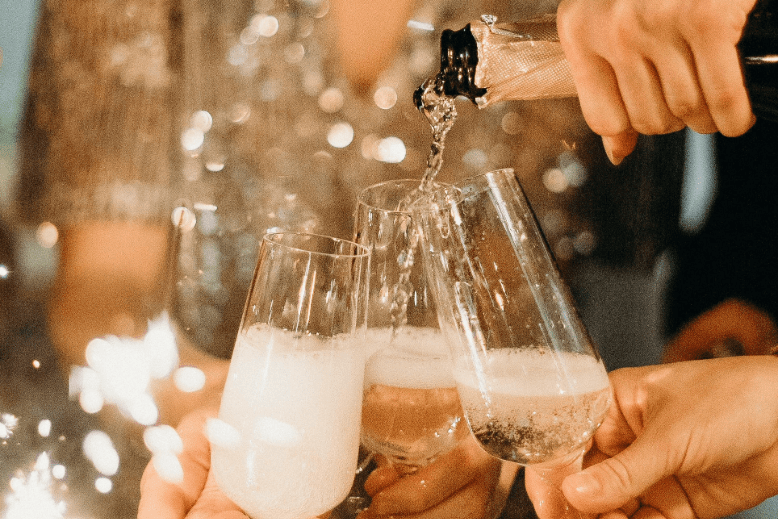 People pouring and toasting Champagne at New Year's Eve party