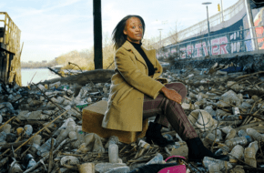 Environmental justice organizer Chloe Desir poses under Newark’s Jackson Street Bridge, which has become a trash dumping ground.
