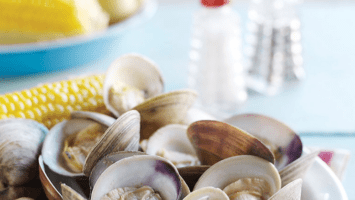 Clams on table with corn and salt and pepper shakers