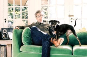 Warren Zanes sitting on a green couch with his dog