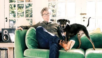 Warren Zanes sitting on a green couch with his dog