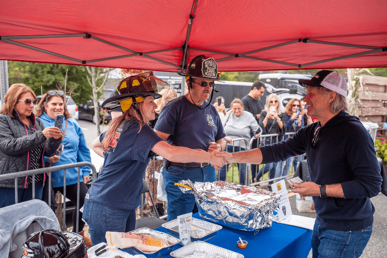 Jon Bon Jovi greets members of the Toms River Fire Department, Company #1, as he tastes their chili.