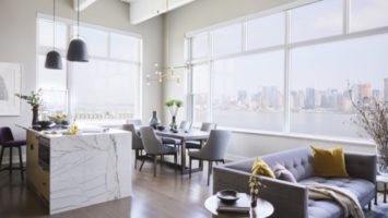 The open-plan kitchen/dining area/living room in a Hoboken condo with a view of the Manhattan skyline