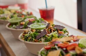 Four colorful salads and a drink with a straw