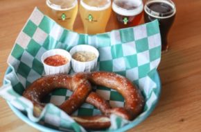 A soft pretzel with several glasses of different beers at Alternate Ending Beer Co. in Aberdeen