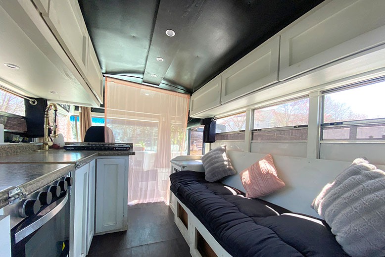 The entrance of Raven Tyler's school-bus home features a small kitchen and a futon