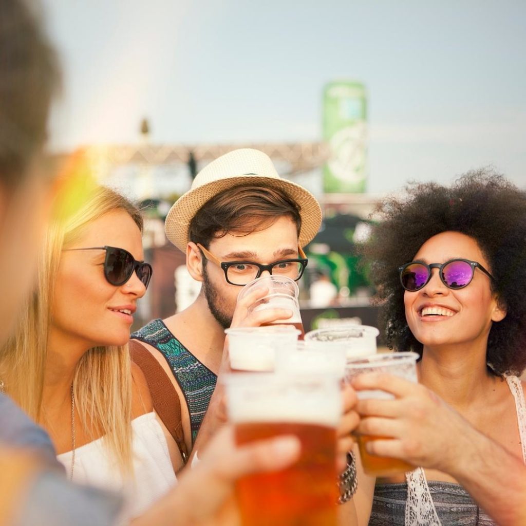 Group of friends drinking beer at outdoor festival