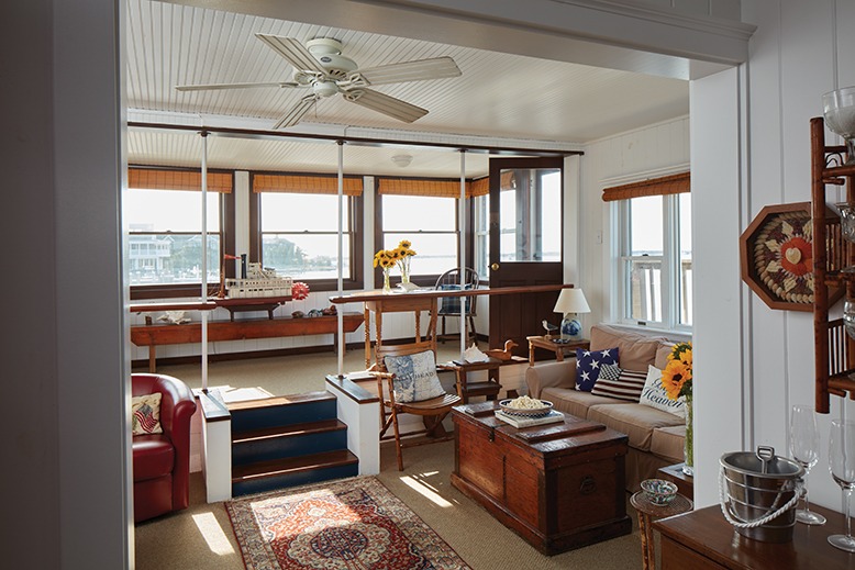 The houseboat's two-tiered living room is surrounded by windows with bay views.