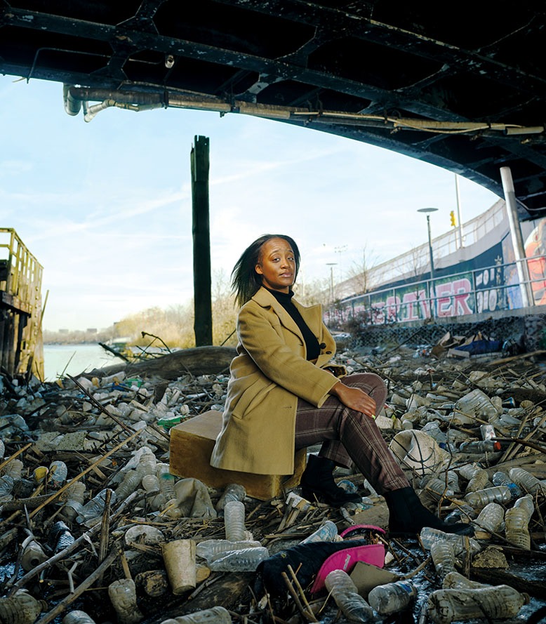 Environmental justice organizer Chloe Desir poses under Newark’s Jackson Street Bridge, which has become a trash dumping ground.
