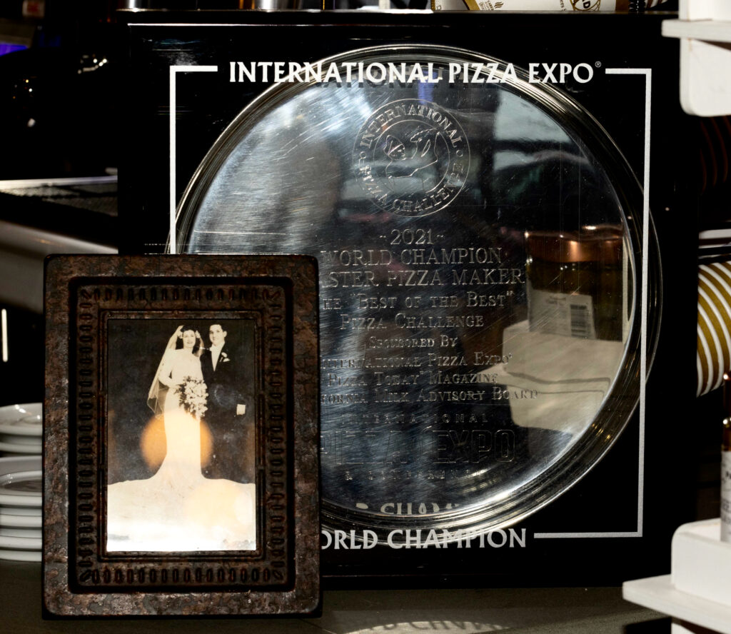 Coniglio's World Champion award from the International Pizza Expo is on display at his restaurant next to a photo of his newlywed grandparents