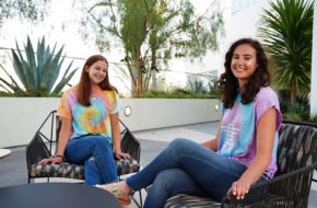 Lauren and Brooke Greenberg sit outside wearing tie-dye apparel from their brand, Tie Dye LAB