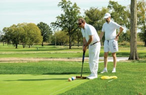 Two men playing golf croquet