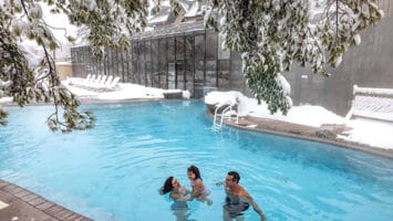 A family in the winter in the indoor/outdoor pool at Mineral Springs Hotel, part of Crystal Springs Resort in Sussex County