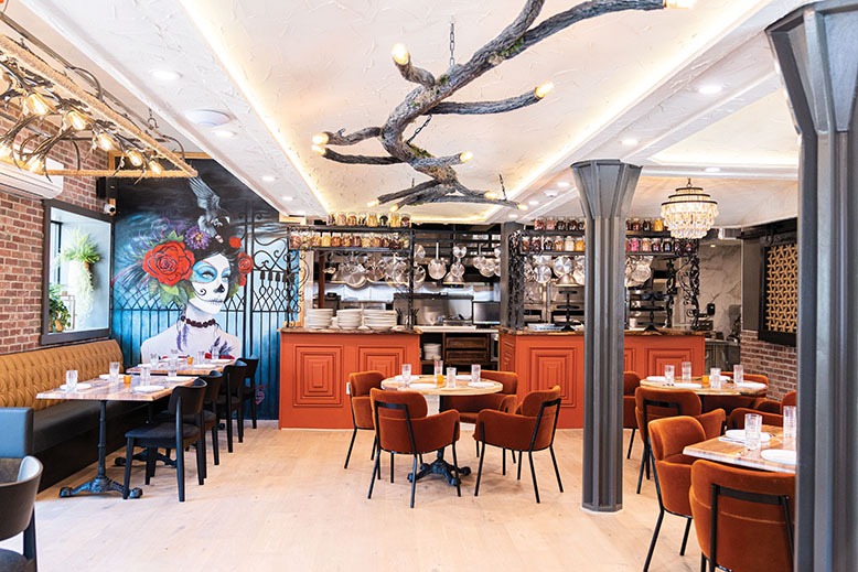 Toca Vez's dining room features an open kitchen and a vibrant mural by local artist Jill Caporoso