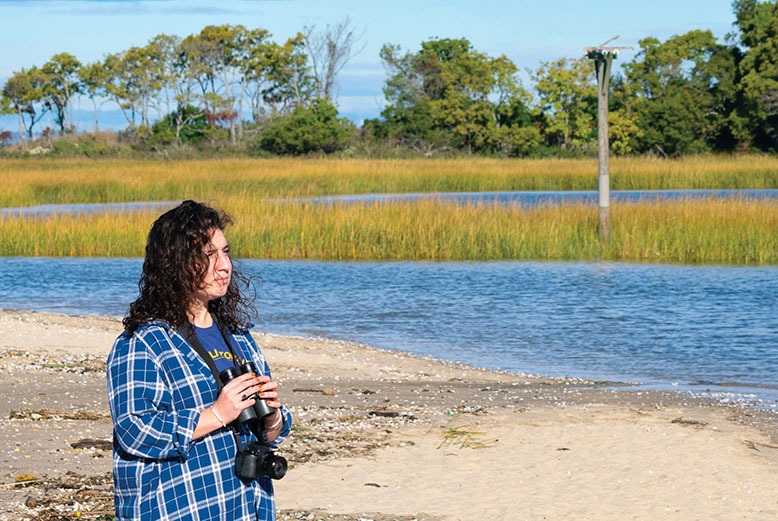 Lindsay McNamara, assistant director of the American Littoral Society, holds binoculars in Sandy Hook