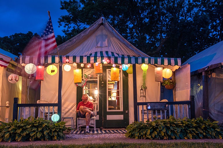 An Ocean Grove resident sits outside his tent at dusk