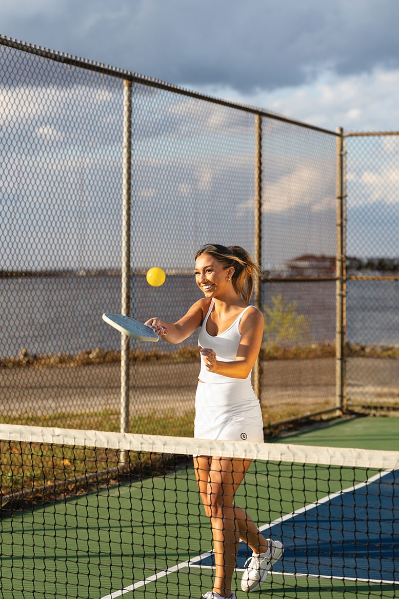 Woman playing pickleball at seaside court