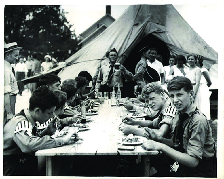 Black-and-white photo of Hitler Youth having a meal together at the German-American Bund Camp Nordland in 1939