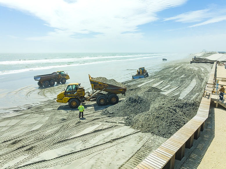 Trucks dump sand from Wildwood onto the beach in North Wildwood