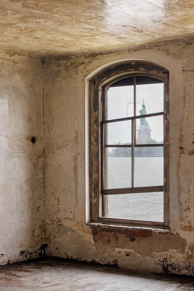 The Statue of Liberty seen through a decrepit window