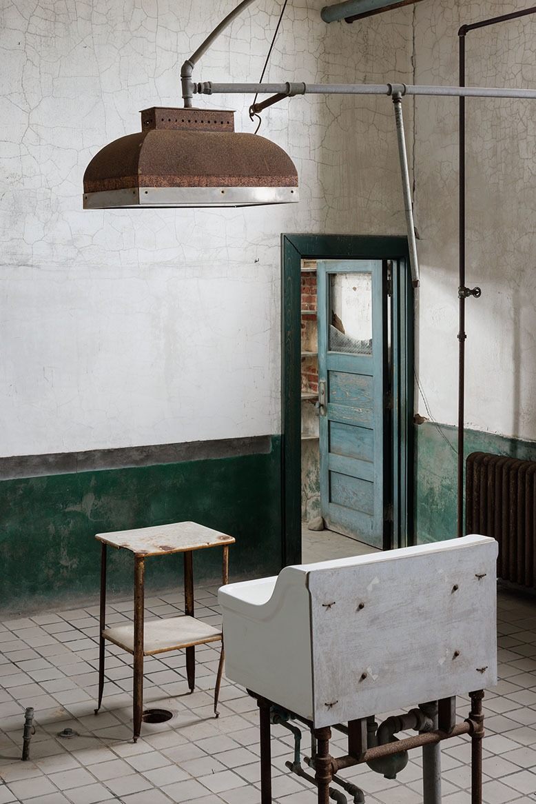 A room in the abandoned complex on Jersey's side of Ellis Island shows an old sink, table and rusty overhead light