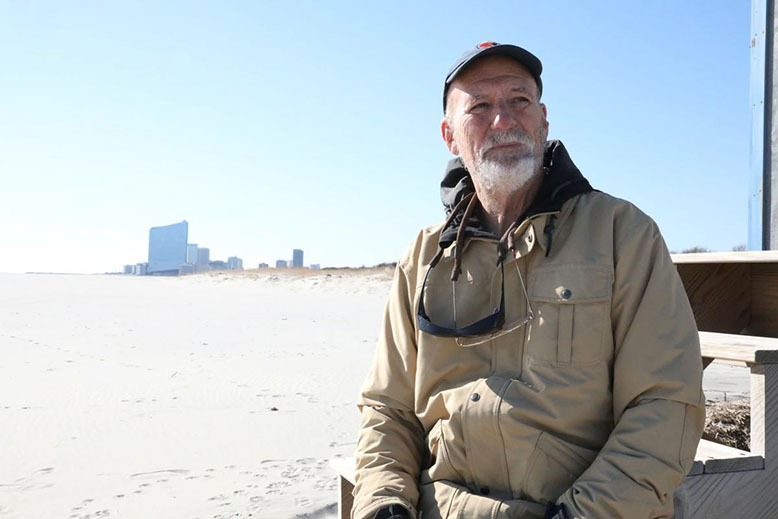 Stockton University’s Stewart Farrell surveys a beach in Brigantine