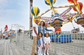 The Sarfo-Darko family amid amusement park attractions on the Point Pleasant boardwalk.