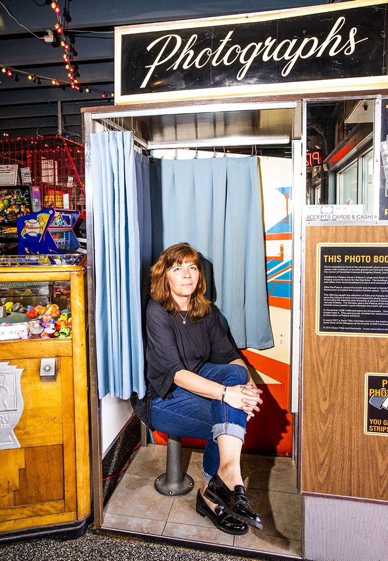 Patty Barber, manager of daily operations at Silverball Retro Arcade in Asbury Park, sits inside the arcade's photo booth