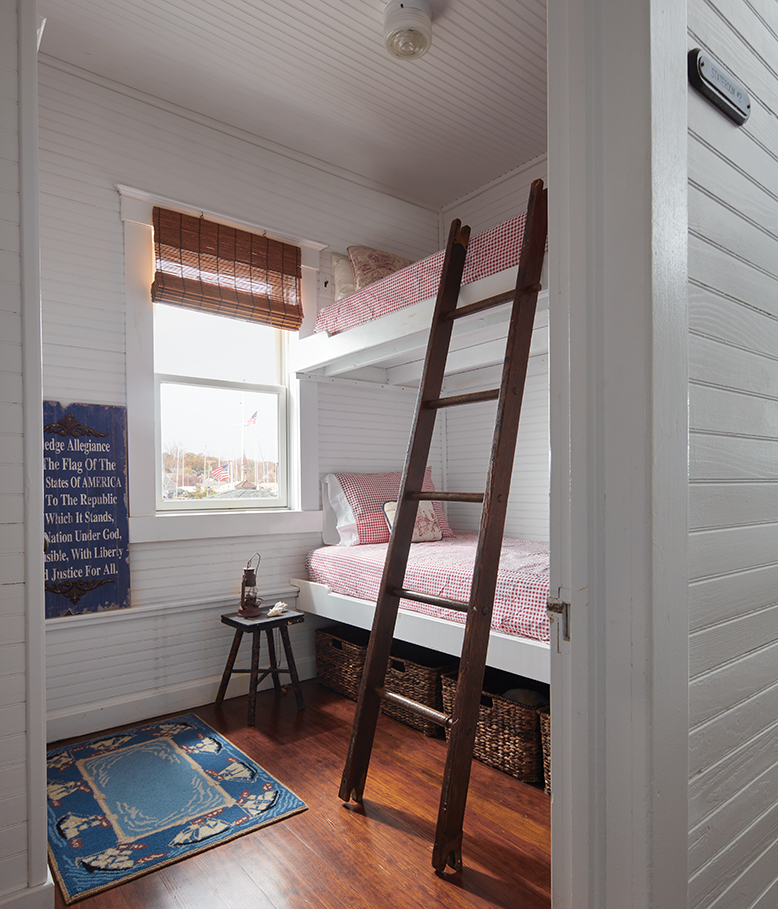 The houseboat's bunkroom, featuring a wooden ladder leading to the top bunk.