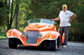 Terry Cook of Chester stands with a vibrant orange convertible car he designed