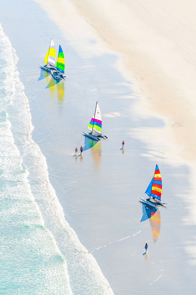 Gray Malin aerial-view print of ocean, sailboats and people on beach