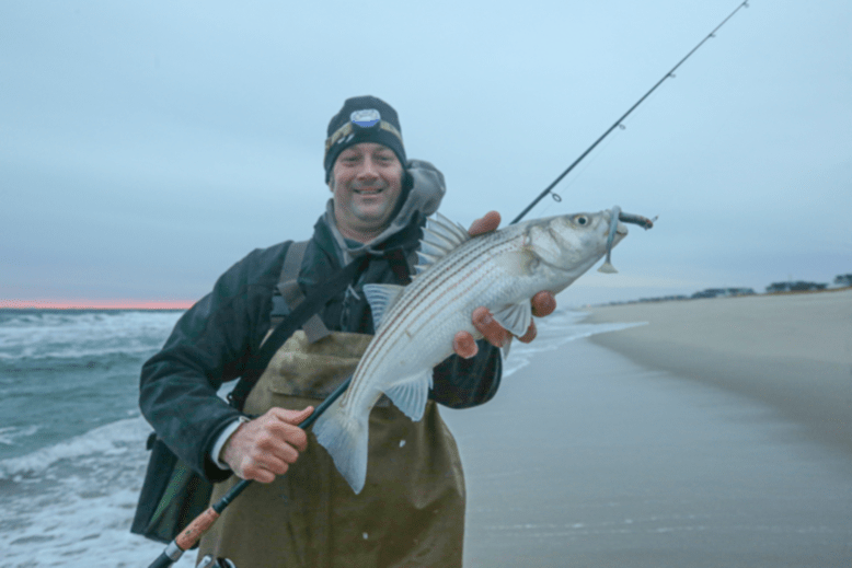 Fishing journalist Nick Honachefsky holds a striped bass in Ocean County