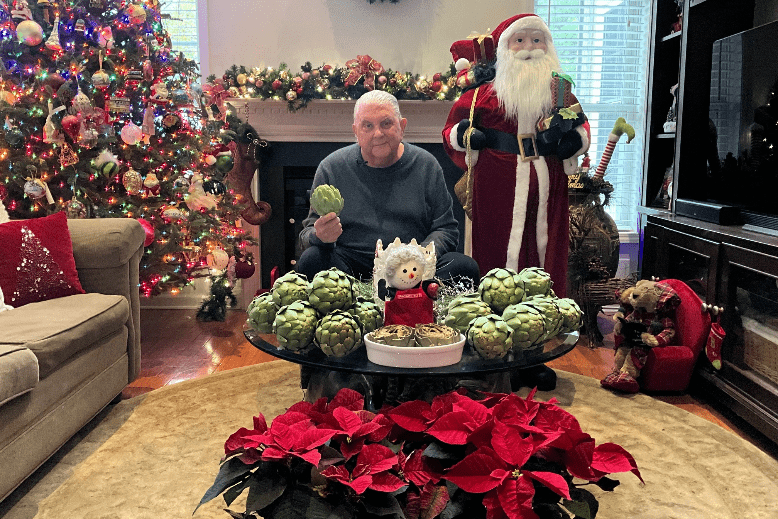 Produce Pete poses with artichokes in his home, decked out for the holidays