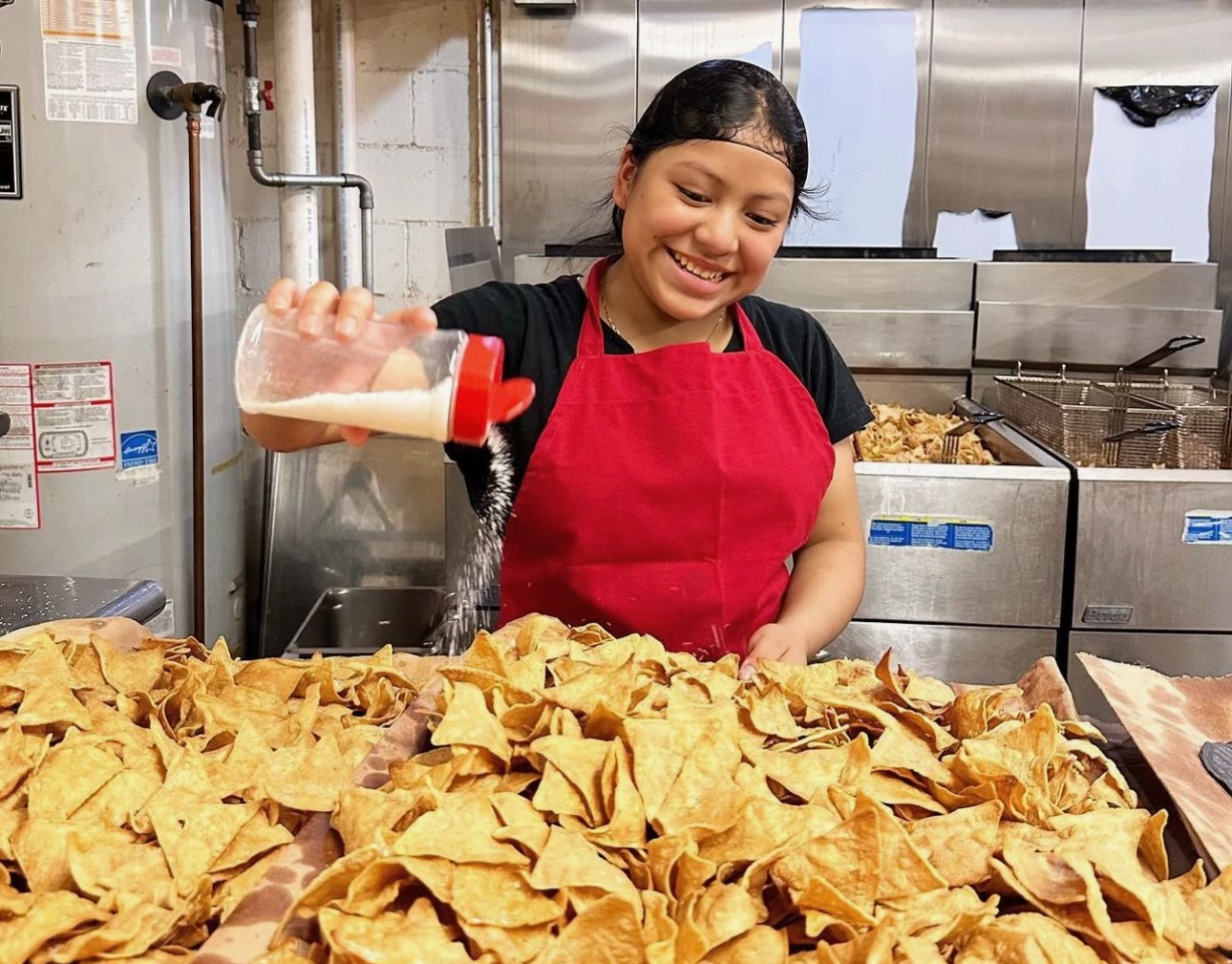 A female employee salts tortilla chips at Tortilleria Nixtamal in Woodland Park