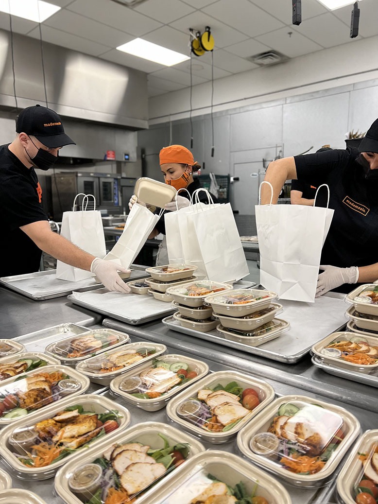 Three employees packing meals in the kitchen