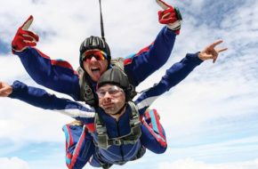 Two skydivers soar through the sky.