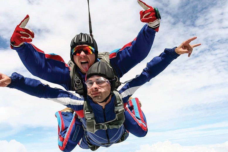 Two skydivers soar through the sky.