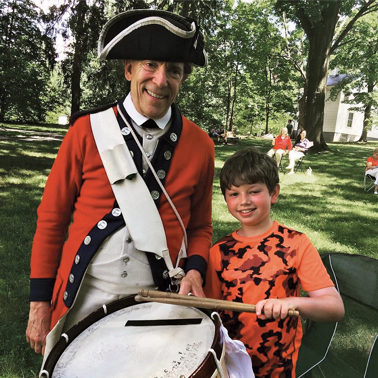 A young visitor poses with a Colonial re-enactor.
