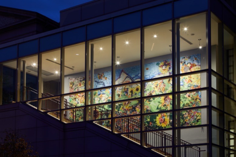 Woolpunk's mixed-media installation seen lit up at night though the windows of Montclair Art Museum